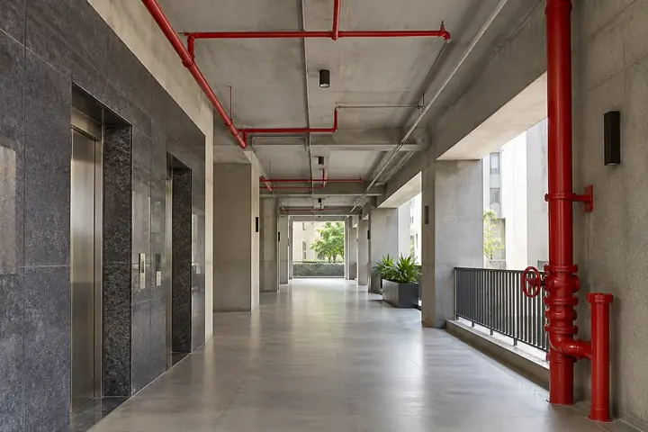 Orderly red fire-service pipework within a clean commercial building corridor