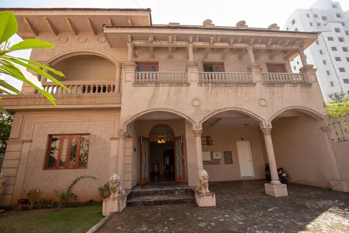 Warm stone-coloured façade with arched openings, carved columns and a balcony from the company project archive