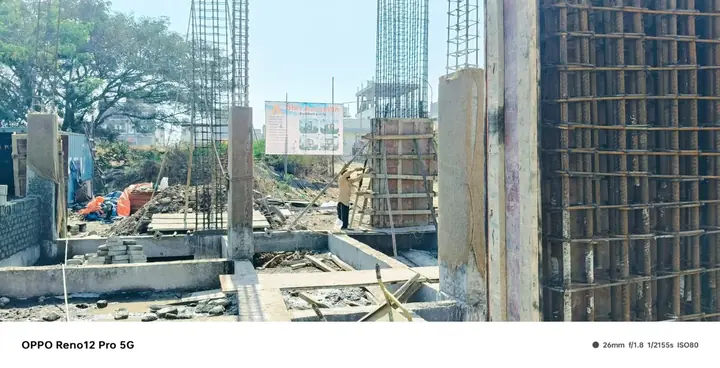 Reinforced concrete columns and foundation masonry on a construction site with a Shri Aarambh Buildtech sign